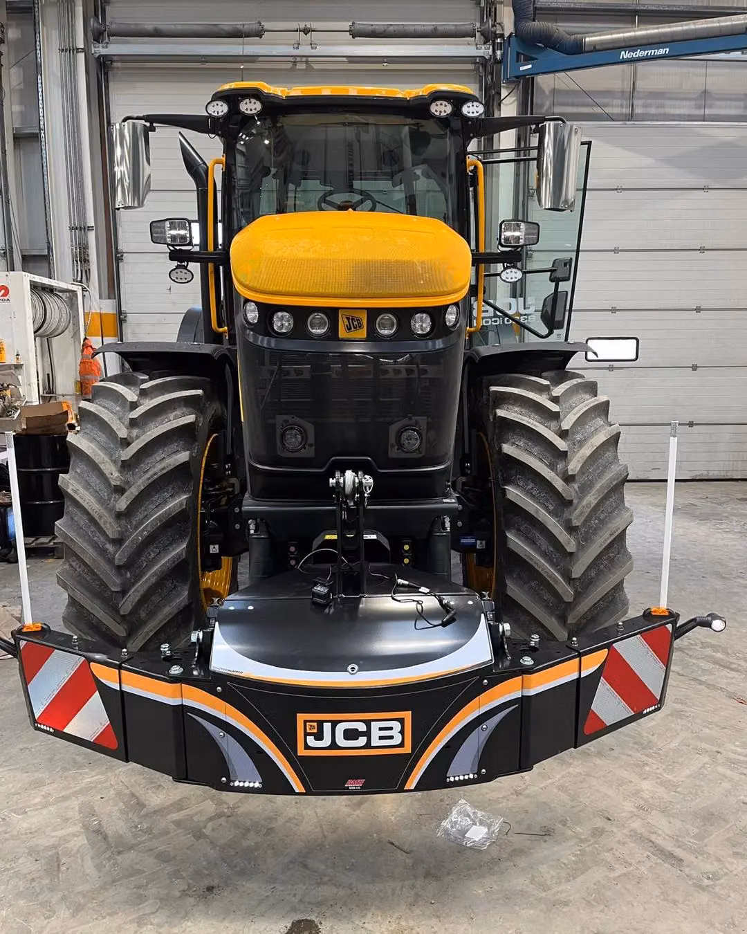 A yellow and black tractor with a mounted front weight bumper featuring LED lights and red and white reflectors