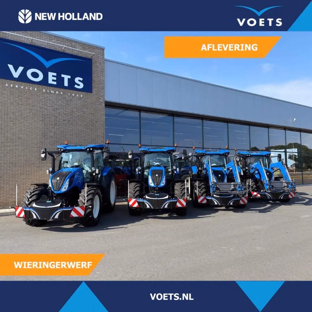 Five blue tractors with front weight bumpers parked in a row outside a dealership building