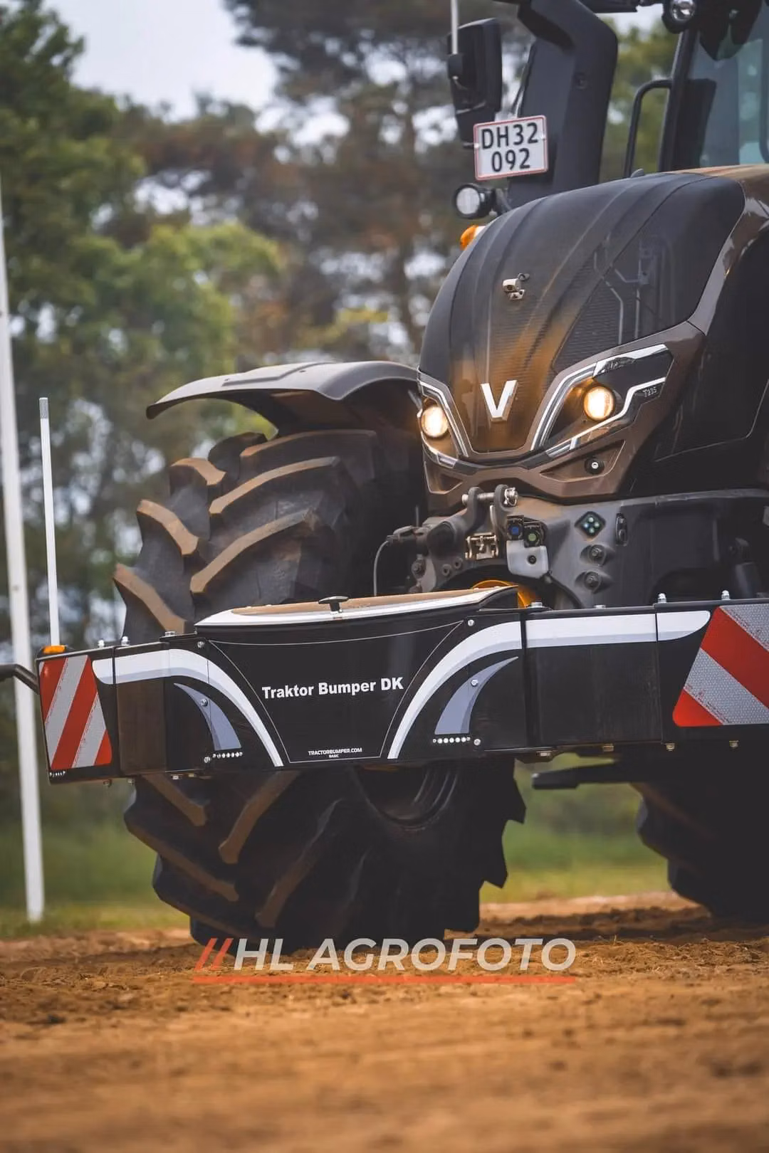 Close-up of a tractor fitted with a Traktor Bumper DK front weight bumper on a dirt surface