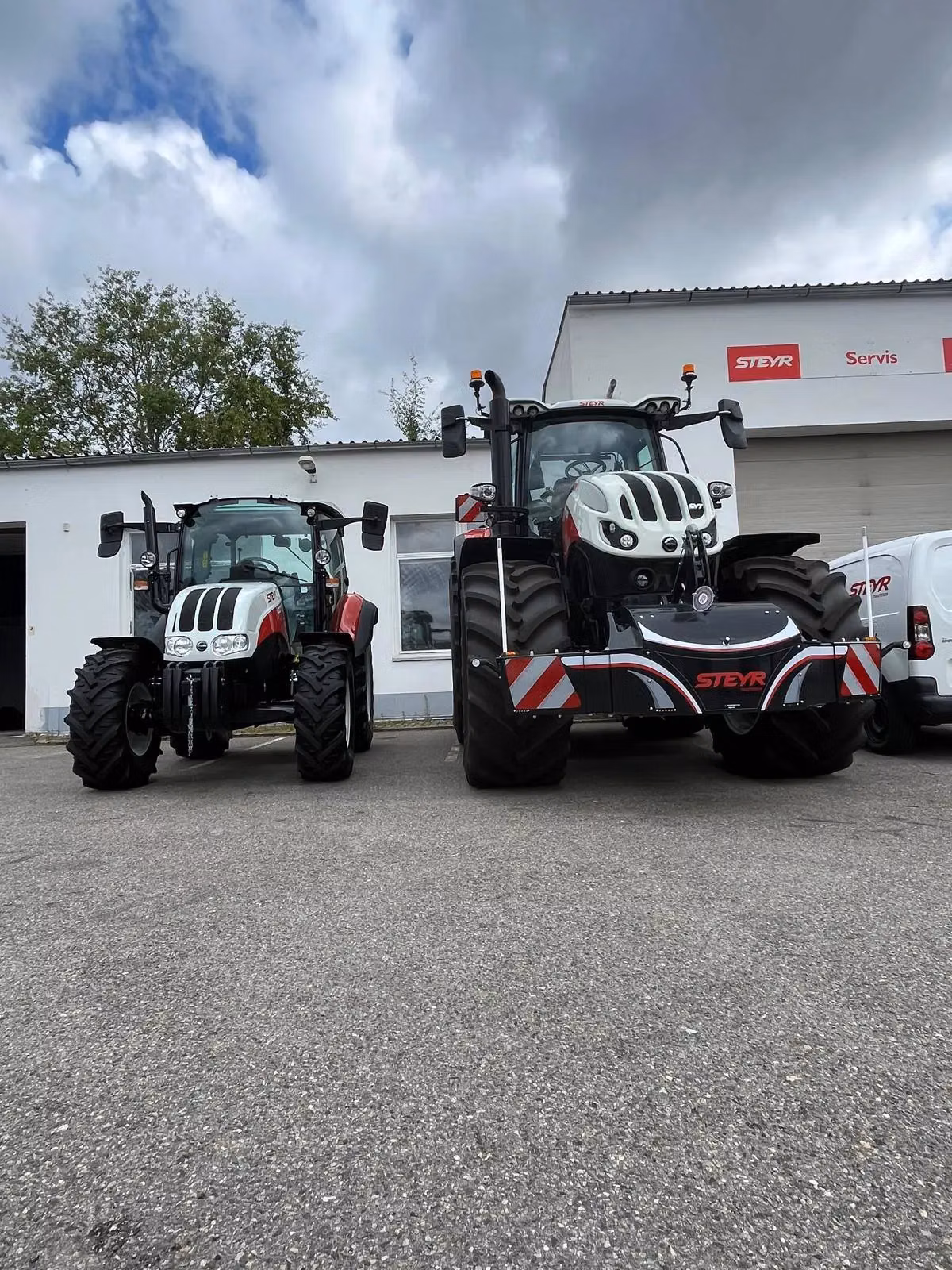 Two Steyr tractors parked side by side, one equipped with a front weight bumper featuring LED lighting