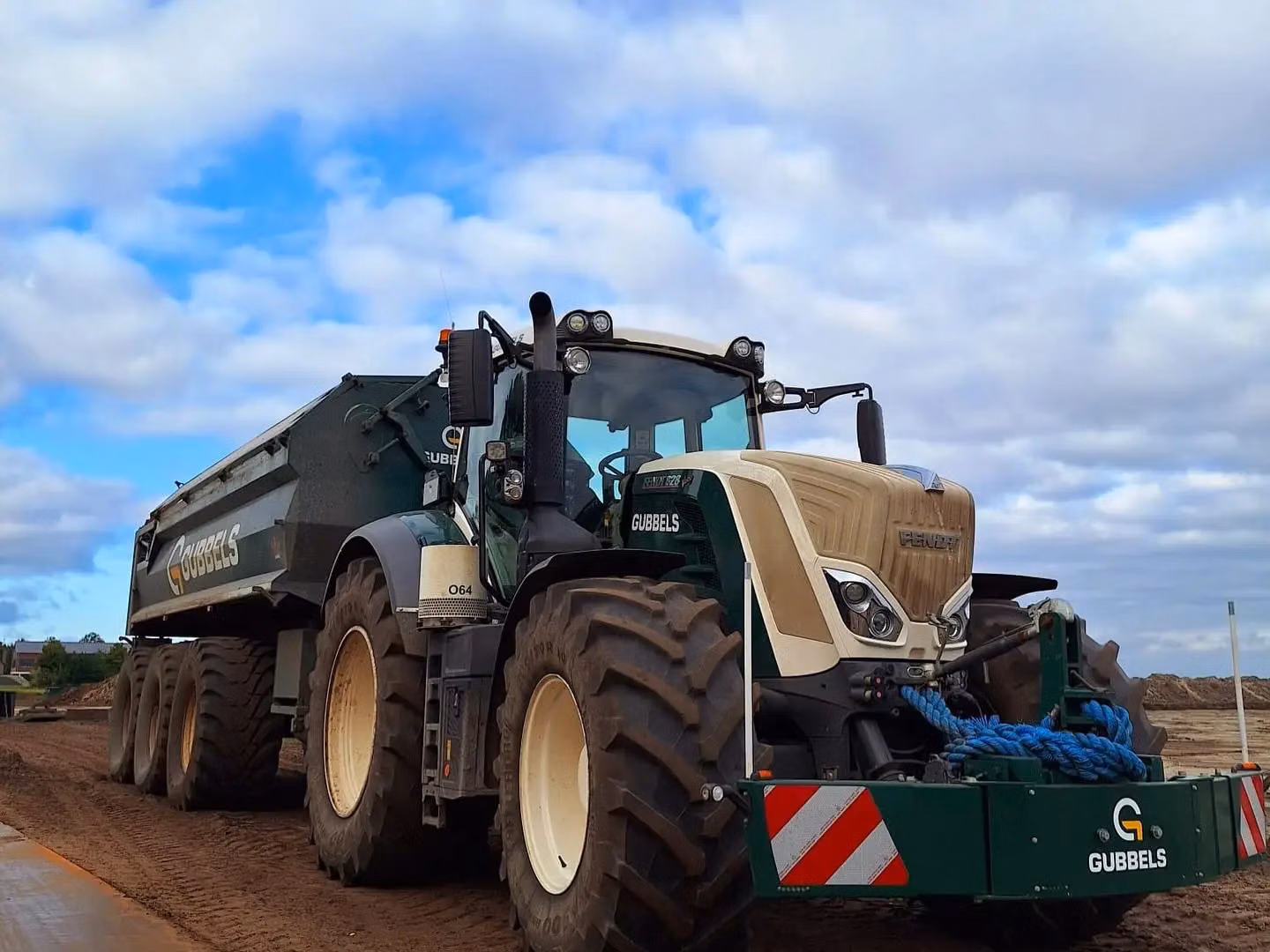 Large tractor with a front weight bumper featuring LED lights, red and white warning stripes and a blue rope attached