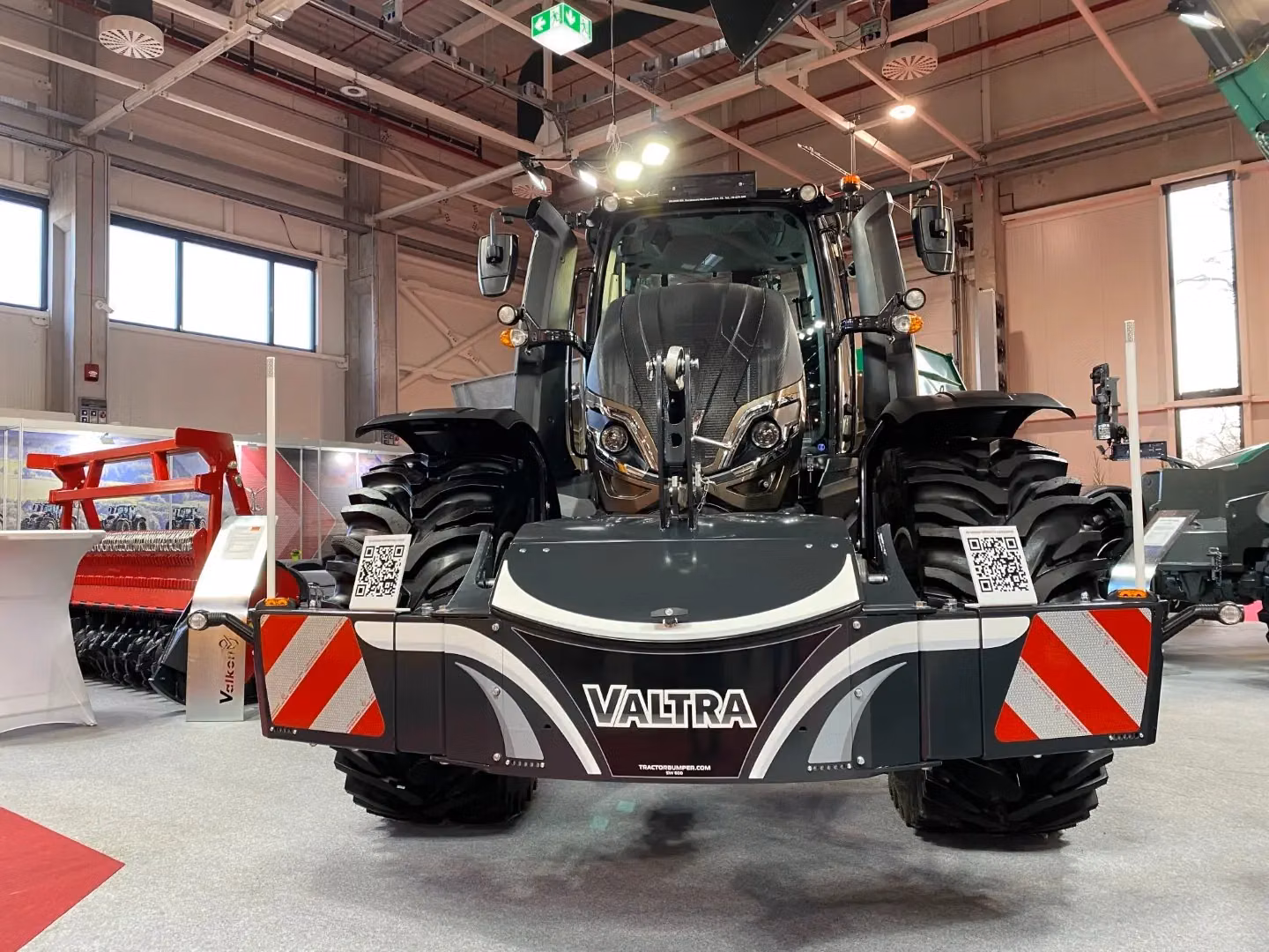 Front view of a Valtra tractor fitted with a box-shaped front weight bumper featuring LED lights and safety markings