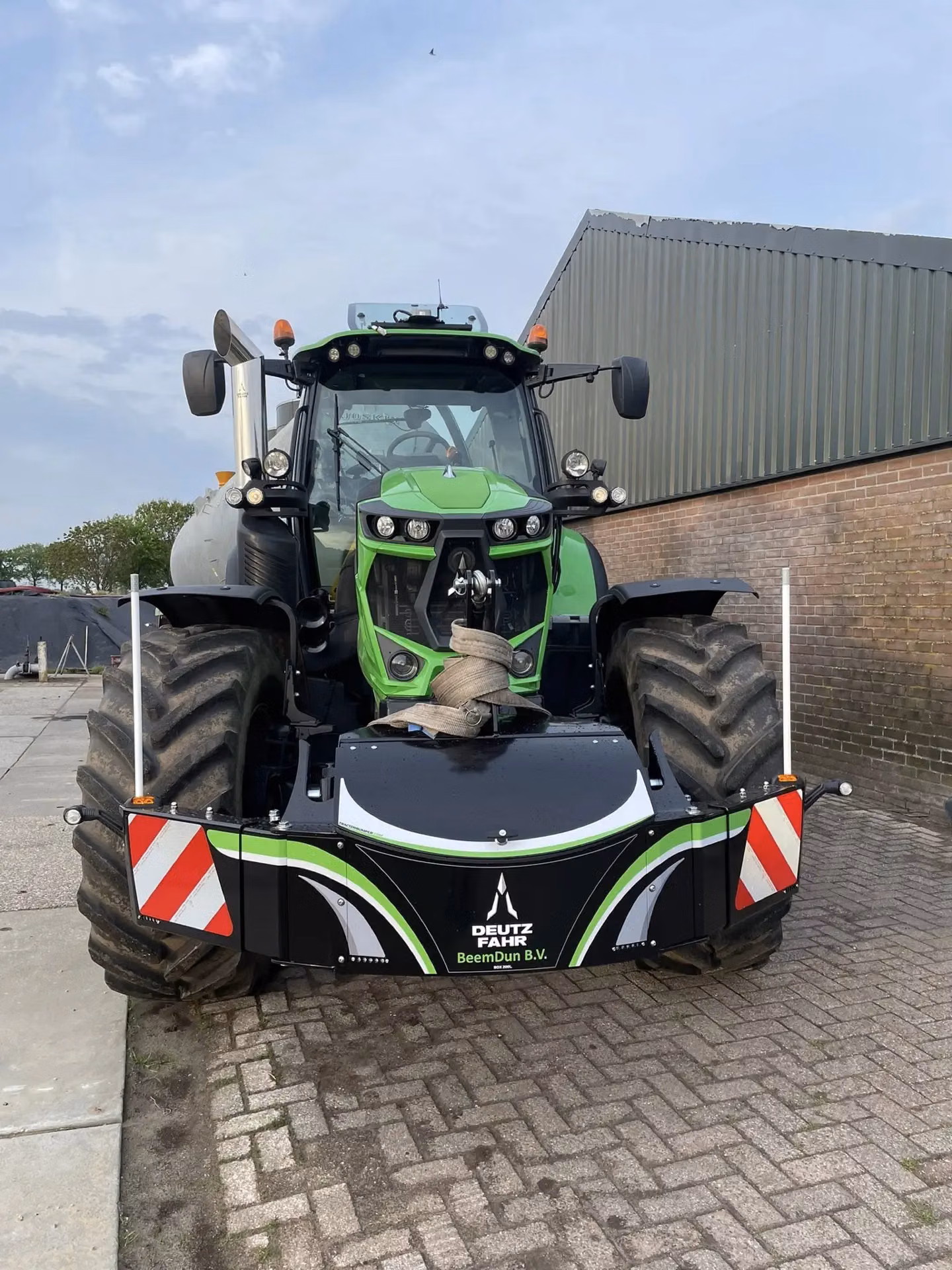 Green tractor with large tires fitted with a black front weight bumper labeled Deutz-Fahr BeemDun B.V.