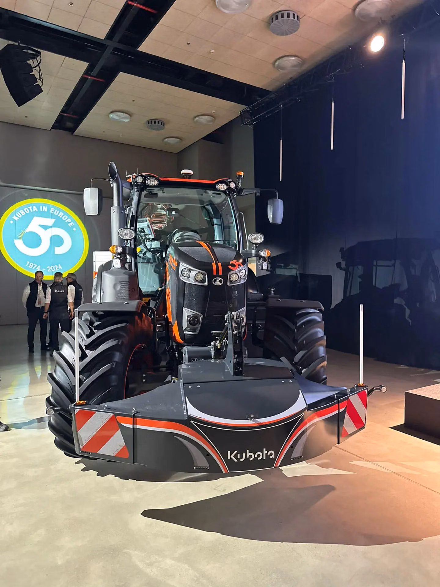A front view of a tractor with a Kubota-branded front weight bumper featuring LED lights and reflective strips