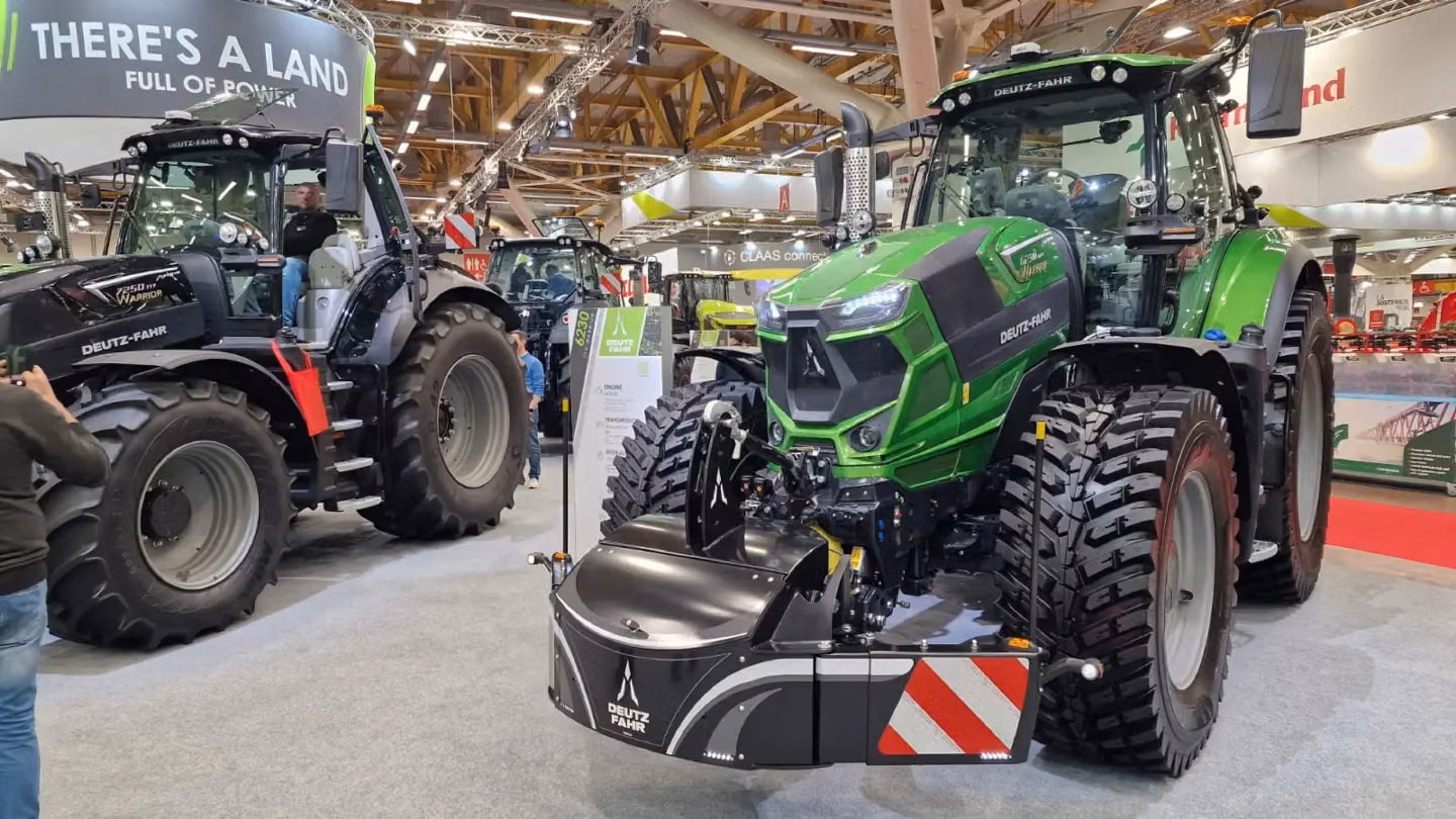 A green tractor fitted with a Deutz-Fahr branded front weight bumper on display at an indoor event
