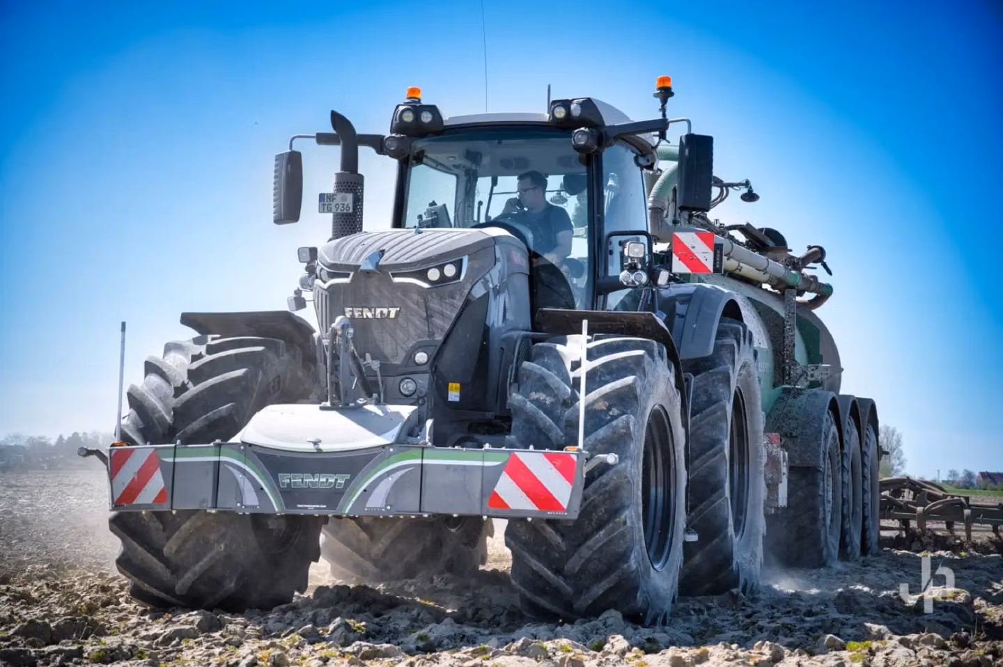 Large tractor with a front weight bumper featuring LED lights and reflective red-and-white panels on a dirt field