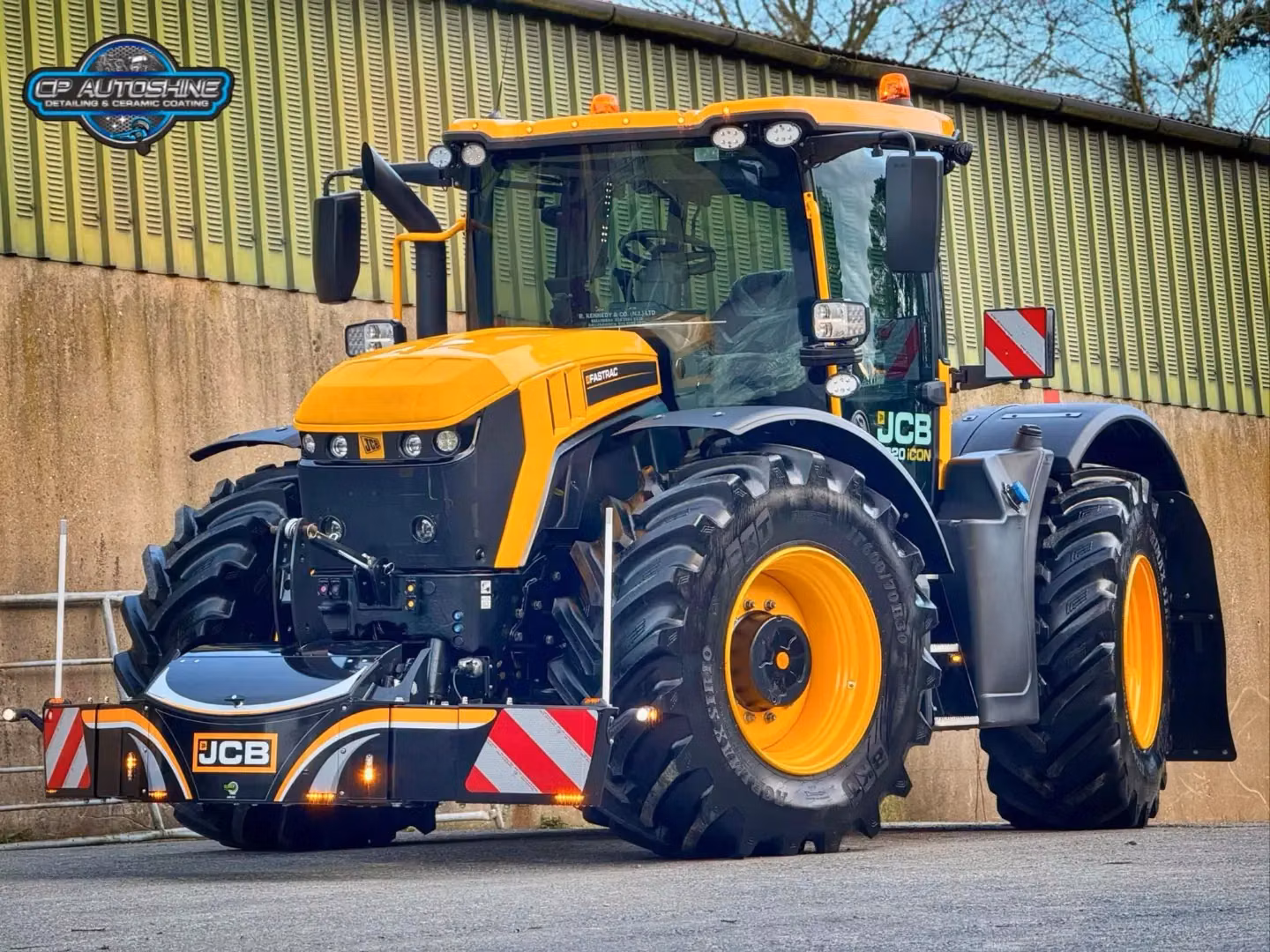 Yellow tractor with large black front weight bumper, reflective red-white stripes, and LED lights attached.