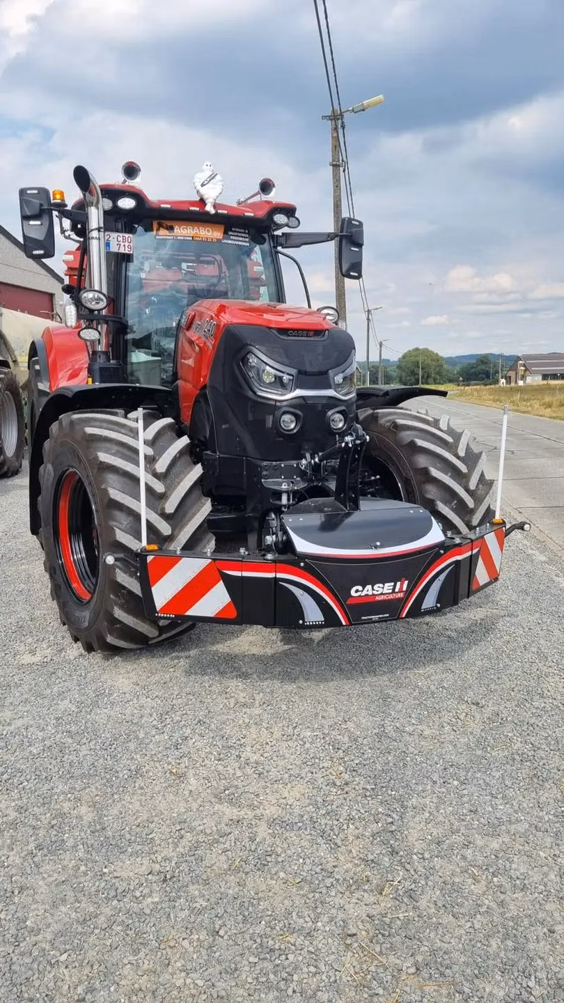 A red tractor fitted with a CASE IH branded front weight bumper with red and white reflective stripes