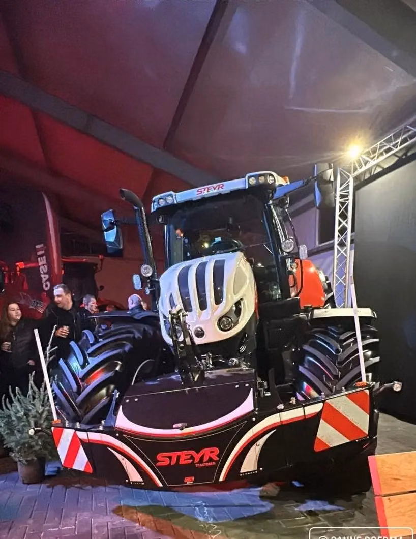 A Steyr tractor indoors with a front weight bumper featuring storage, LED lighting and red-and-white safety stripes