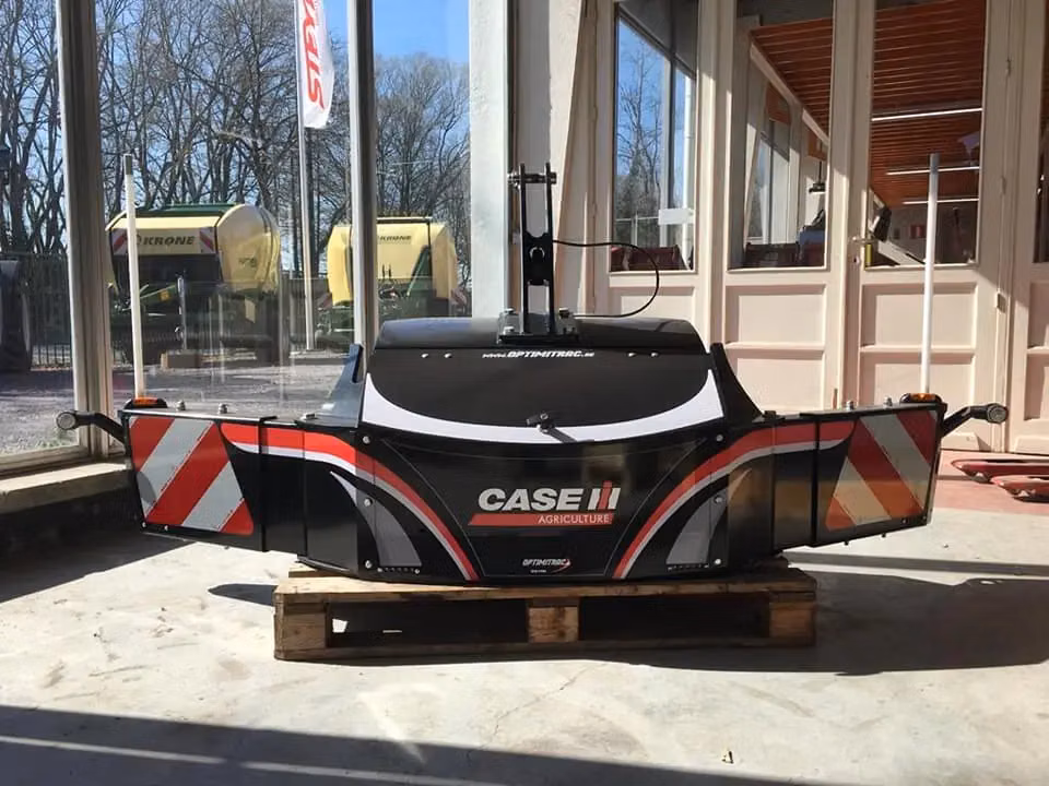 Black Case IH front weight bumper with reflective red and white panels, displayed indoors on a wooden pallet